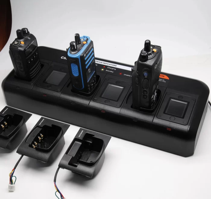 Two walkie talkies charging on a battery charger